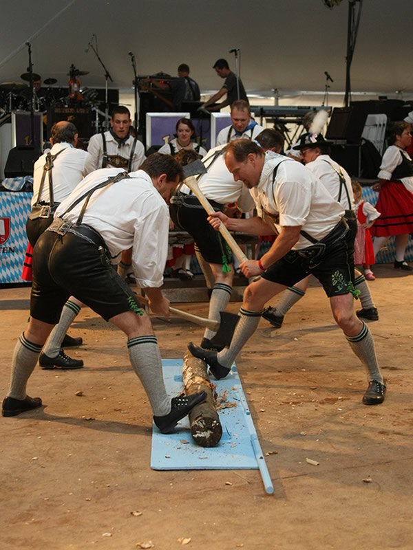 Dancers performing the Holzhacker woodchopper dance with axes and a log